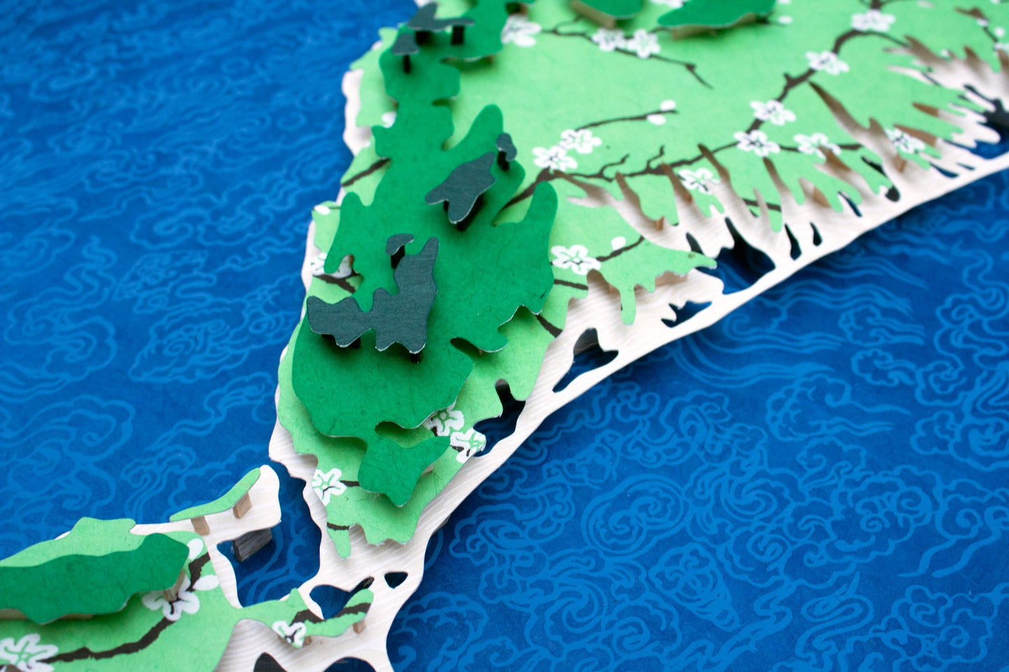 Framed original cut paper topographical map of Martha's Vineyard Island against beautiful blue Japanese paper background.