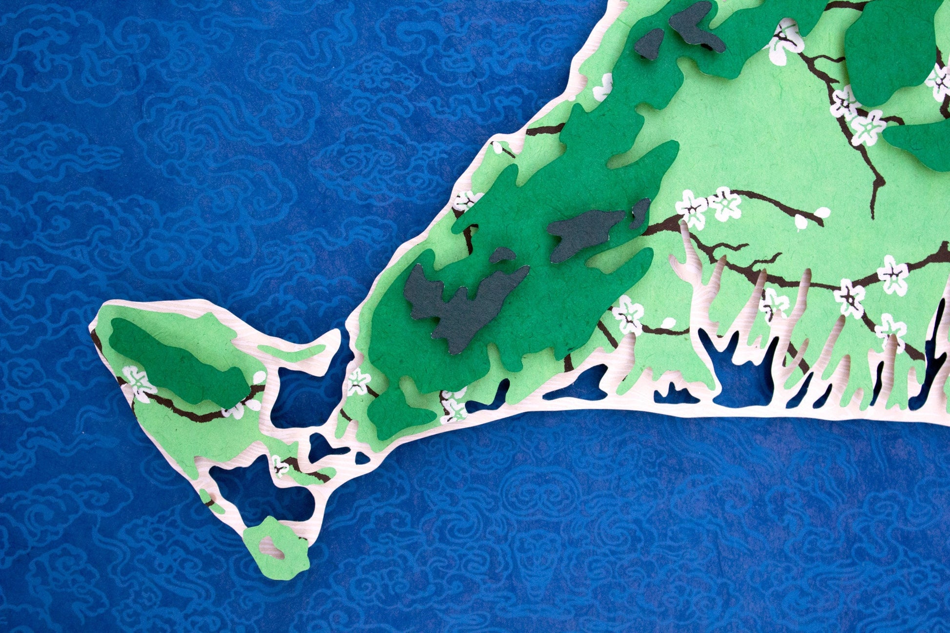 Framed original cut paper topographical map of Martha's Vineyard Island against beautiful blue Japanese paper background.