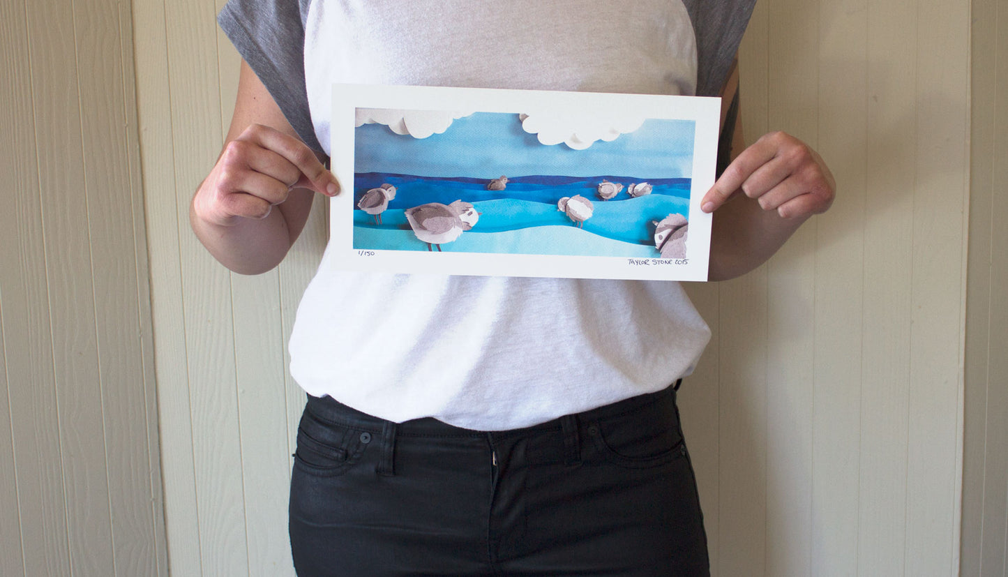 Archival print of cut paper illustration of cute piping plover birds in the ocean.