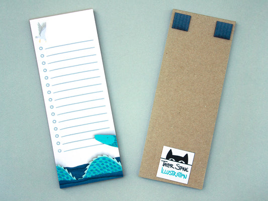 Cute notepad with cut paper illustration of blue sea serpent monster at bottom and sea gull at top.