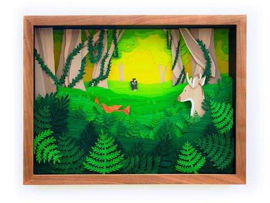 Framed cut paper illustration of cute forrest scene with deer, fox, and hiker.