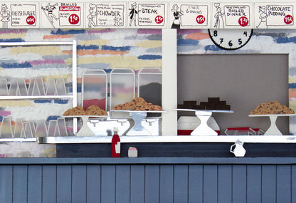 Archival print of cut paper illustration of the inside of the ArtCliff Diner on Martha's Vineyard, showing details of baked goods on the counter.