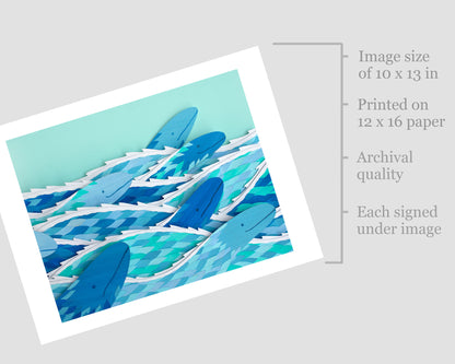 Archival print of cut paper illustration of several cute blue sea serpents swimming.