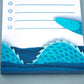Cute notepad with cut paper illustration of blue sea serpent monster at bottom and sea gull at top.